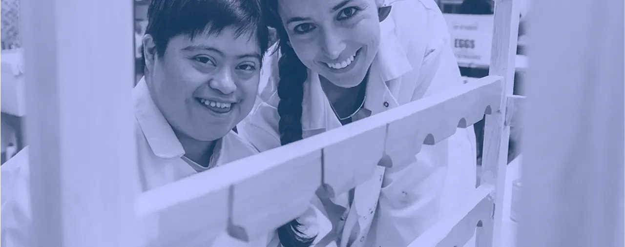 Workers smiling behind wooden frame