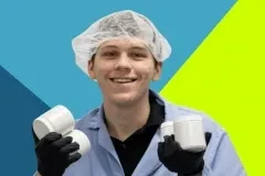Worker in hairnet holding containers