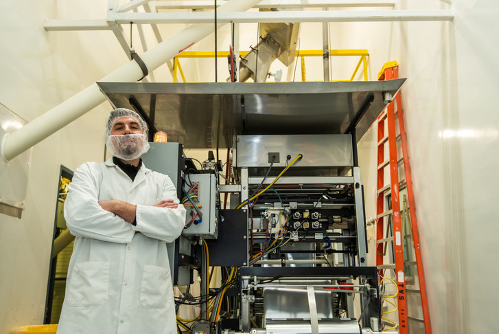 man with arms crossed standing in front of equipment