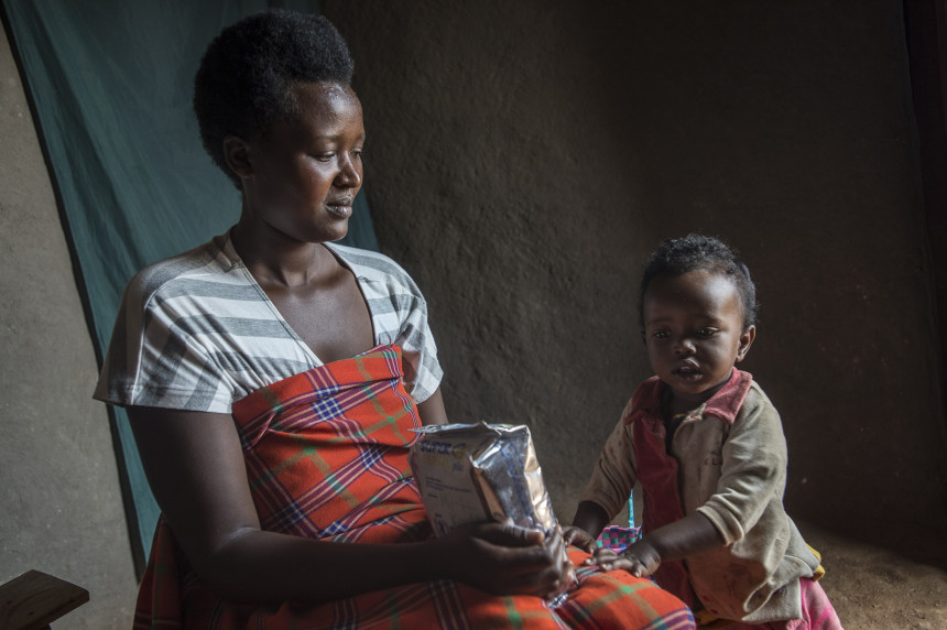 woman holding super cereal plus bag and sitting next to child